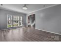 Bright living room with hardwood floors, large windows, and an open view of the staircase at 98 Poplar Woods Dr, Concord, NC 28027