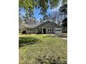 Inviting single-story home with a well-manicured lawn, classic architecture, and attached garage at 104 Edgewater Nw Dr, Concord, NC 28027