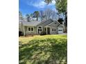 Beautiful single-story home with a gray exterior, lush green lawn, and mature trees at 104 Edgewater Nw Dr, Concord, NC 28027