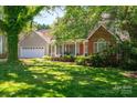 Traditional home with a lush, green lawn, mature trees, and a welcoming front porch, providing curb appeal at 107 Southfork Dr, Belmont, NC 28012