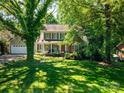 Traditional home with a lush, green lawn, mature trees, and a welcoming front porch, providing curb appeal at 107 Southfork Dr, Belmont, NC 28012
