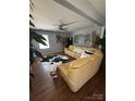 Open living room featuring a tan leather sectional sofa and ceiling fan at 110 Buffalo Nw Ave, Concord, NC 28025