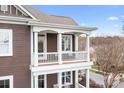 A balcony with a white railing overlooks the neighborhood street, offering a peaceful outdoor space at 11204 Arlen Park Dr, Huntersville, NC 28078