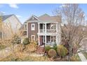 This stunning two-story home features a charming double porch, mature landscaping, and a classic design at 11204 Arlen Park Dr, Huntersville, NC 28078