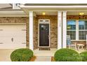 Classic front door with sidelights, white columns, brick facade, and neatly trimmed landscaping at 1129 Black Walnut Rd, Clover, SC 29710