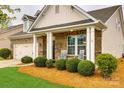 Inviting front porch with rocking chairs, manicured bushes, and brick facade with decorative columns at 1129 Black Walnut Rd, Clover, SC 29710