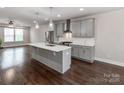 Modern kitchen with gray cabinets, quartz countertops, stainless steel appliances, and hardwood floors at 11939 Fiddlers Roof Ln, Charlotte, NC 28277