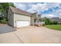 This home has a two-car garage, a long driveway, and a cute covered front porch at 1812 Sam Smith Rd, Fort Mill, SC 29708