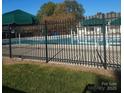 Community pool surrounded by a black fence and green umbrellas, creating a refreshing retreat at 19057 Coachmans Trce, Cornelius, NC 28031