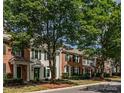 A picturesque street view of well-maintained townhouses with lush trees lining the sidewalk at 19057 Coachmans Trce, Cornelius, NC 28031
