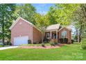Charming brick home boasting an attached garage, front porch, and a meticulously maintained yard at 2104 Congress Ct, Kannapolis, NC 28083
