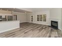 Open-concept living room featuring modern gray flooring, fireplace, and seamless connection to the kitchen at 2104 Congress Ct, Kannapolis, NC 28083