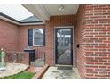 Charming entrance with a secure screen door, classic brick, and a neatly arranged garden area at 3921 Sage Ct, Denver, NC 28037