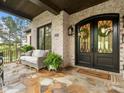 Charming front porch with a cozy seating area, stone floor, and decorative front door wreaths at 4012 Flagstone Dr, Lancaster, SC 29720