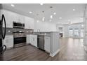 Modern kitchen featuring stainless steel appliances, granite countertops and a view of the living room at 4211 Center Place Dr, Harrisburg, NC 28075