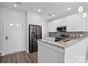 Bright kitchen with white cabinetry, stainless steel refrigerator, and granite countertops at 4211 Center Place Dr, Harrisburg, NC 28075
