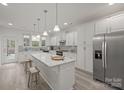 A kitchen featuring a large island with wooden stools and stainless steel appliances at 5109 Arbordale Way, Mount Holly, NC 28120