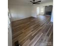 Spacious living room boasts gleaming hardwood floors, abundant natural light, and a cozy fireplace at 6372 Morehead St, Harrisburg, NC 28075
