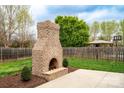 Outdoor brick fireplace and stone patio provide a cozy backyard living space, perfect for entertaining at 641 Weyburn Nw Dr, Concord, NC 28027