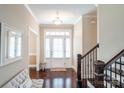 Elegant foyer featuring hardwood floors, a staircase with dark wood railing, and natural light at 641 Weyburn Nw Dr, Concord, NC 28027