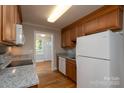 Bright kitchen with hardwood floors, granite counters, and a full suite of white appliances at 676 Forest Nw St, Concord, NC 28025