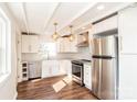 Spacious kitchen with stainless steel appliances, bright white cabinets, granite counters, and modern lighting at 678 Wagner St, Troutman, NC 28166