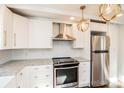 White cabinets, stainless appliances, subway tile backsplash, and granite counters highlight the kitchen at 678 Wagner St, Troutman, NC 28166