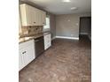 Well-lit kitchen with white cabinets, stainless steel dishwasher and adjoining tile flooring at 705 3Rd Nw Ave, Hickory, NC 28601