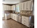 Bright kitchen with white cabinets, stainless steel dishwasher, and stylish backsplash at 705 3Rd Nw Ave, Hickory, NC 28601