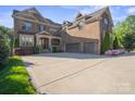 A luxurious brick home is showcased with an attached three-car garage and manicured landscaping, creating a grand and inviting entrance at 7944 Park Rd, Charlotte, NC 28210