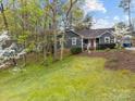 Cozy home with a sloped front yard, mature trees, and lush landscaping at 813 Deer Path Pl, Mooresville, NC 28115