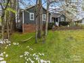 Backyard view with lush green grass, a hammock, and a swing hanging from mature trees at 813 Deer Path Pl, Mooresville, NC 28115