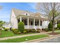 Inviting home showcasing a quaint front porch, lush landscaping, and timeless design elements at 9514 Wheatfield Rd, Charlotte, NC 28277