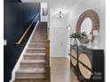 Stylish entryway features a staircase, modern decor, a round mirror, and a decorative cabinet at 9710 Ainslie Downs St, Charlotte, NC 28273