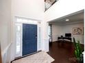 Welcoming entryway featuring a blue front door, hardwood floors, and an open view into a bright office space at 9878 Verdun Ct, Fort Mill, SC 29707