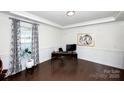 Bright home office with wainscoting, a large window with curtains, and hardwood floors for a professional workspace at 9878 Verdun Ct, Fort Mill, SC 29707