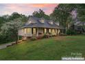 Beautiful home with a lush lawn, mature trees, and an inviting front porch with swings at 109 Windmill Rd, Salisbury, NC 28147