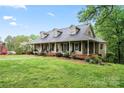 Charming home featuring a wide front porch with ample seating, lush lawn, and beautiful landscaping at 109 Windmill Rd, Salisbury, NC 28147