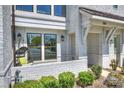 Charming front porch with a swing, brick accents, and manicured landscaping at 1105 Reece Rd, Charlotte, NC 28209