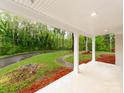 Covered porch with white columns offers a view of the spacious front lawn and driveway at 1113 Gregory Ln, Statesville, NC 28677