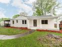 Inviting white brick home featuring a covered porch and lush green lawn at 1113 Gregory Ln, Statesville, NC 28677