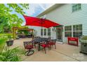 Inviting back patio with an outdoor dining set, pergola, and mature trees, ideal for entertaining at 117 Middleton Pl, Mooresville, NC 28117