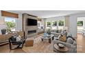 Sunlit living room with modern fireplace, hardwood floors, neutral palette, and views of the outdoors at 130 Fordham Ct # 18, Fort Mill, SC 29715