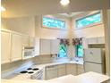 Charming kitchen boasts white appliances, ample cabinetry, and plenty of natural light from multiple windows at 14613 Waterside Dr, Charlotte, NC 28278