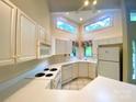 Charming kitchen boasts white appliances, ample cabinetry, and plenty of natural light from multiple windows at 14613 Waterside Dr, Charlotte, NC 28278