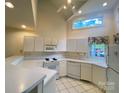 Bright kitchen with white cabinets, countertops, and appliances, plus a window and a ceiling fan at 14613 Waterside Dr, Charlotte, NC 28278