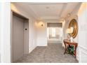 Hallway view showcasing neutral carpeting, trim, and a convenient elevator access at 14849 Santa Lucia Dr, Charlotte, NC 28277
