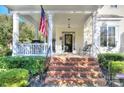 Inviting front porch with brick steps, black door and classic white pillars at 15236 Waterfront Dr, Huntersville, NC 28078