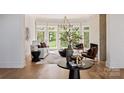 Bright living room featuring large windows, hardwood floors, a fireplace and stylish decor at 15603 Mccullers Ct, Charlotte, NC 28277