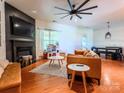 Spacious living room with a fireplace, a large ceiling fan, and hardwood floors at 1814 Woods Ln, Denver, NC 28037